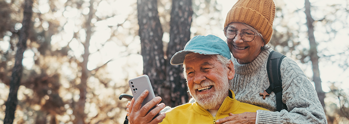 Senior man and woman smiling into man's phone